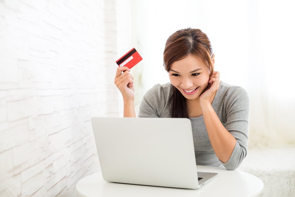 Woman enjoy online shopping paying by credit card